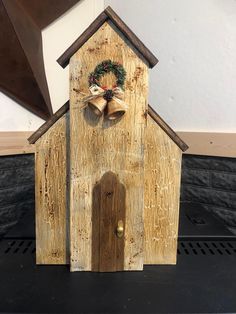 a small wooden church with a wreath on the front door and bell at the top