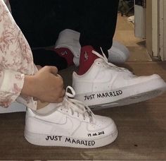 two people standing next to each other wearing white sneakers with just married written on them