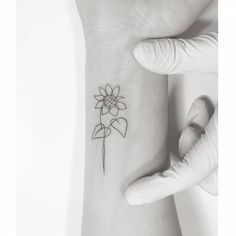 a woman's arm with a flower tattoo on the left side of her wrist