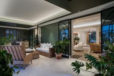 a living room filled with lots of furniture and plants on top of it's windows