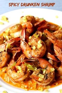 a white plate topped with cooked shrimp and garnished with lemon zeurce