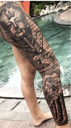 a man's leg with tattoos on it and an image of the egyptian god