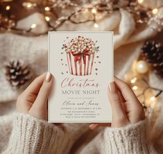 a woman holding up a christmas movie night card