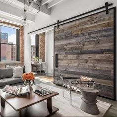 a living room filled with furniture and a wooden sliding door in front of a window