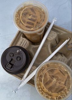 two plastic cups with lids and straws on a tray