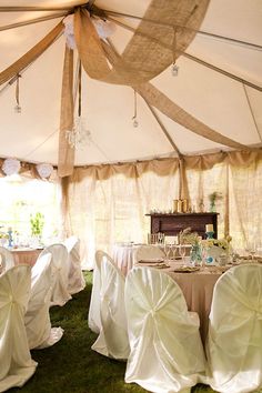 the inside of a tent with tables and chairs