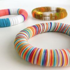 three different colored bracelets sitting next to each other