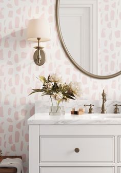 a bathroom vanity with a mirror and flowers on it