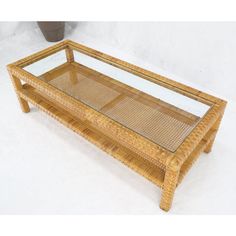 a coffee table made out of bamboo with glass top and wicker frame on the bottom