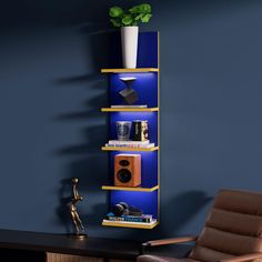 a blue shelf with books and speakers on it next to a chair in a room