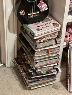 a guitar sitting on top of a stack of magazines