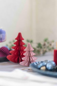 small plastic christmas trees sitting on top of a table next to other ornaments and decorations