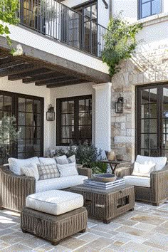 an outdoor living room with wicker furniture and stone flooring is pictured in this image