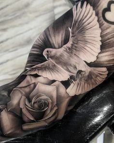 a black and white photo of a bird with a rose on it's arm