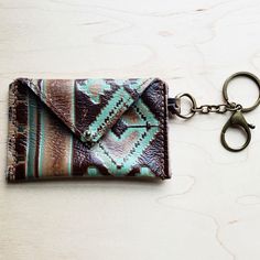 a small wallet with a keychain hanging from it's side on a table