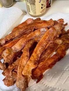 bacon strips on a napkin next to a jar of mayonnaise