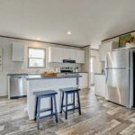 a kitchen with two stools and an island in front of the refrigerator freezer