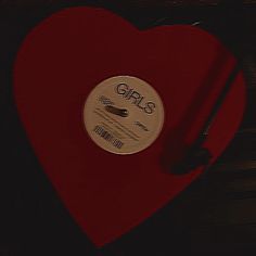 a red heart shaped object with the word girls on it's side and a black background