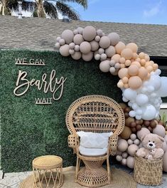 an outdoor area with balloons, chairs and a teddy bear on the grass next to a sign that says we can bearly wall