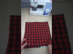 the sewing machine is on the table next to the red and black plaid material that has been sewn