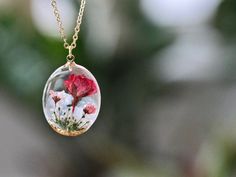 This necklace features a rose, the birth flower for June, carefully preserved in a clear resin pendant. The rose symbolizes love, royalty, beauty, sensuality, secrecy, and mysticism, making this necklace a perfect personalized birthday gift. Material: 14k gold filled chain and components, Resin Flower: Real Pressed Flower Chain Length: 16" (40cm) , 18" (45cm)  Pendant Width: 0.79" (2cm) Pendant Height: 0.98" (2.5cm) Every pieces is made by hand and unique, therefore each piece might be slightly different. Comes packed with a gift bag or box. This is a handmade product, there is a tiny possibility of imperfections and micro bubbles.