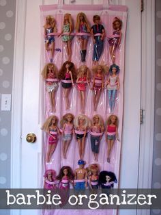 barbie dolls are lined up on the wall in front of a door that is decorated with pink and white polka dots