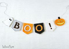 a halloween banner made out of felt with the word boo spelled in black and orange