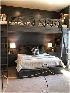 a bedroom with a loft bed and two lamps on either side of the bed, in front of a bookshelf