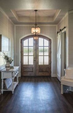 an entryway with wooden floors and two doors