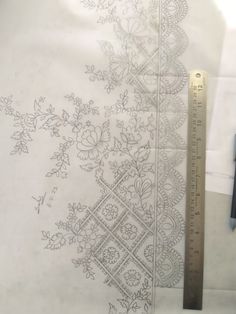 a ruler is next to an intricately designed piece of fabric