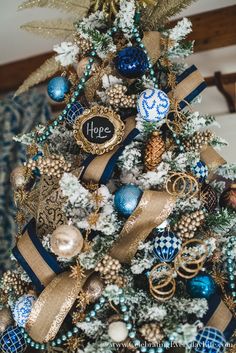 a decorated christmas tree with blue and gold ornaments