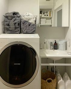 a washer and dryer sitting in a bathroom next to each other on a shelf