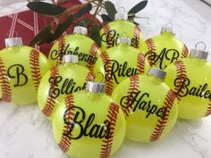 six yellow baseball ornaments with black lettering on them