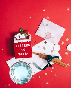 a letter to santa is sitting on top of a table next to an envelope and christmas decorations