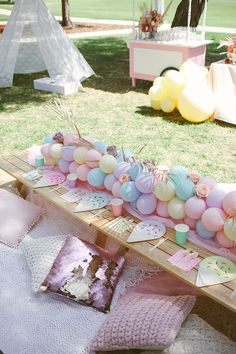 a table topped with lots of cake and balloons