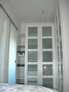 an empty bedroom with glass doors leading to the closet