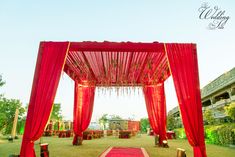 an outdoor wedding setup with red drapes