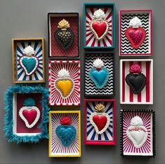 there are many small boxes with hearts in them on the wall next to each other