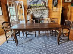 a dining room table and chairs in front of a fire place with a horse head on the wall