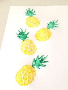 three pineapples painted on white paper with green stems and yellow centers, sitting next to each other