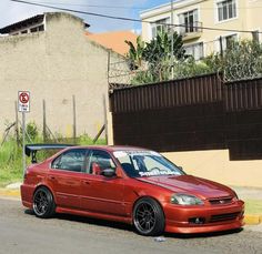 a red car is parked on the side of the road