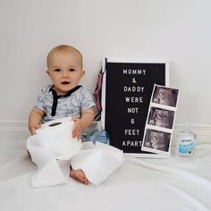 a baby is sitting on the bed with toilet paper in front of him and his photo next to it