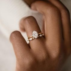 a woman's hand holding a diamond ring