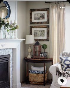 a living room filled with furniture and a fire place in front of a mirror on the wall