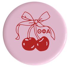 a pink button with two cherries tied to it's side and the word ao on top