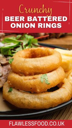 onion rings are stacked on top of each other in front of some meat and vegetables