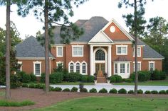 a large red brick house surrounded by trees