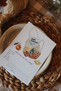 a card that is sitting on top of a plate next to some bread and an orange