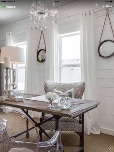 a living room filled with furniture and a chandelier hanging from the ceiling over a table