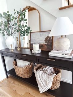 a black table with two baskets on it and a lamp in the corner next to it